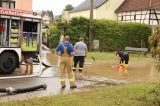 Nach einem Starkregen pumpen Einsatzkräfte der Feuerwehr auf dem Dorfplatz von Hilbersdorf das Wasser ab. Nach heftigen Gewittern kam es in Ostthüringen zu zahlreichen Überschwemmungen.