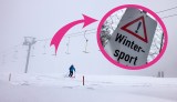 Eine vereinsamte Skipiste in Thüringen. Ein Pfeil zeigt auf ein Warnschild mit der Aufschrift "Achtung Wintersport".